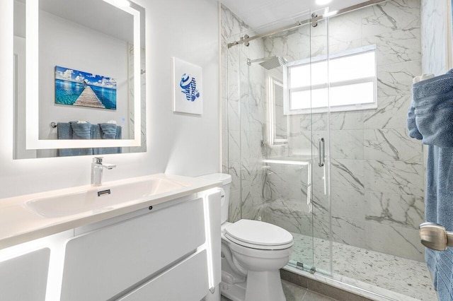 full bathroom featuring toilet, a marble finish shower, and vanity