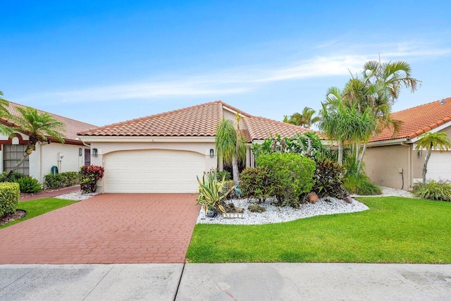 mediterranean / spanish-style house featuring a garage, decorative driveway, a tiled roof, and stucco siding