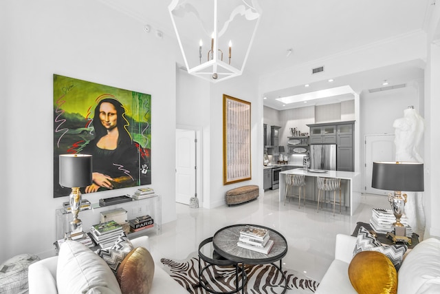 living room featuring a chandelier, ornamental molding, light tile patterned flooring, baseboards, and a towering ceiling