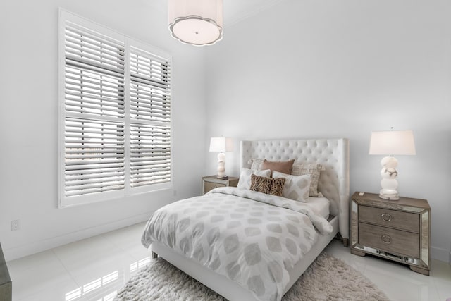 bedroom with tile patterned floors, crown molding, and baseboards