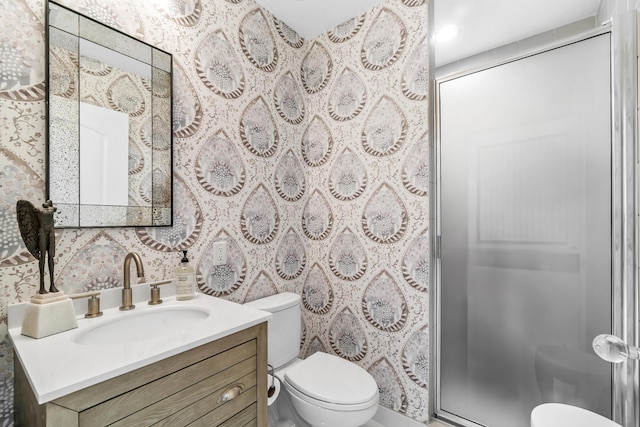 bathroom with toilet, a shower stall, and vanity