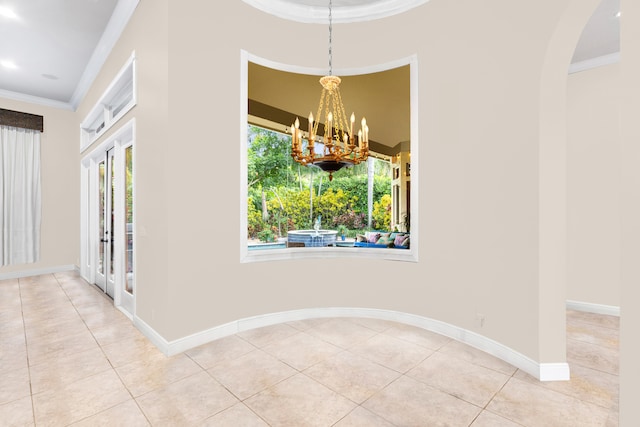 unfurnished dining area with crown molding, tile patterned flooring, french doors, a chandelier, and baseboards