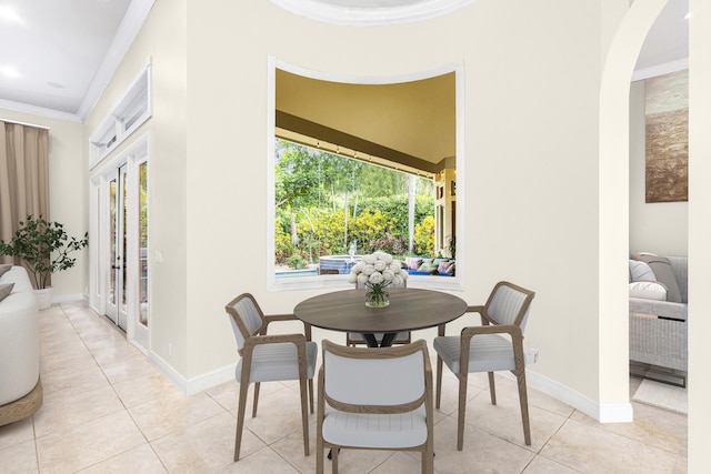 dining space with crown molding, french doors, light tile patterned floors, arched walkways, and baseboards