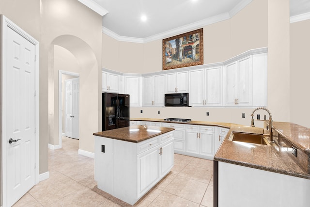 kitchen with black appliances, a sink, ornamental molding, white cabinetry, and light tile patterned floors