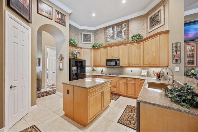 kitchen featuring black appliances, a sink, arched walkways, a towering ceiling, and crown molding