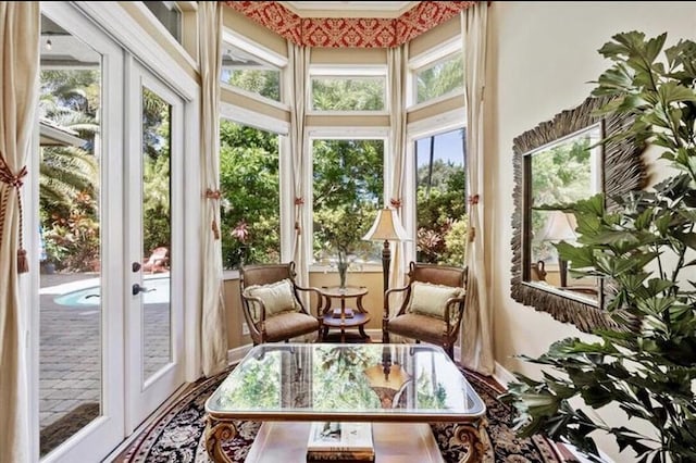sunroom / solarium featuring french doors and a high ceiling