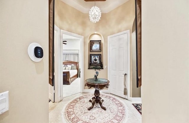 foyer with baseboards and a chandelier