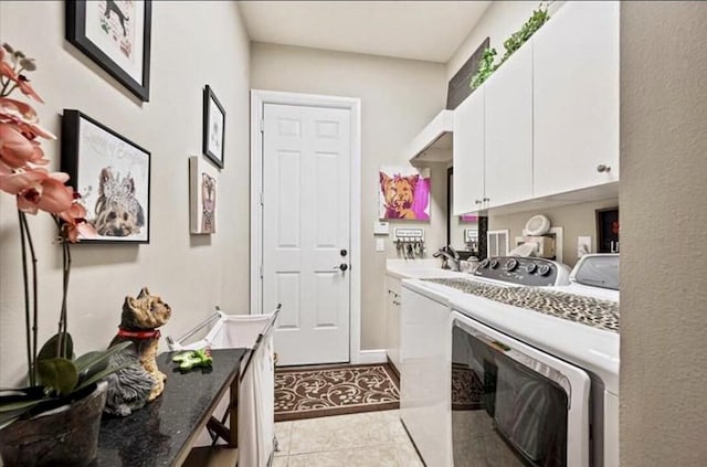 laundry room with independent washer and dryer, cabinet space, and light tile patterned floors