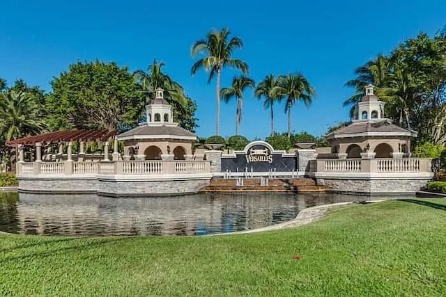 surrounding community featuring a water view and a lawn