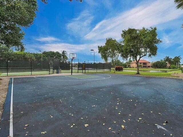 view of basketball court featuring community basketball court, fence, and a tennis court