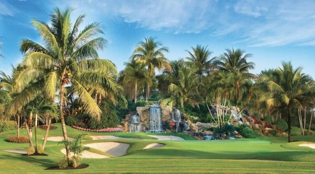 surrounding community with view of golf course and a yard