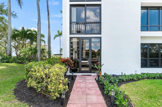property entrance featuring stucco siding and a lawn