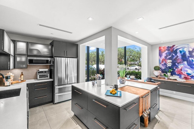 kitchen with stainless steel appliances, light countertops, tasteful backsplash, a center island, and recessed lighting