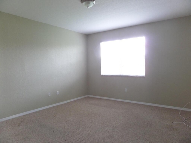 empty room with light carpet and baseboards