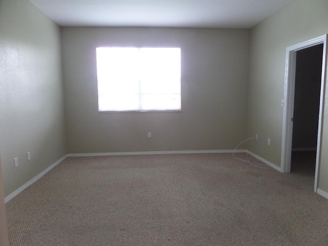 empty room with light carpet and baseboards