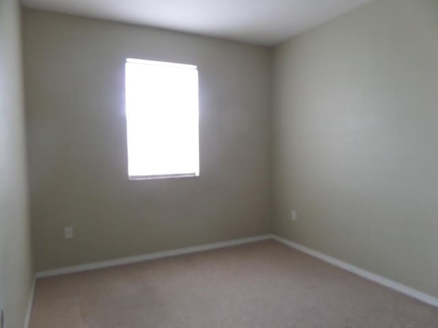 carpeted empty room with baseboards