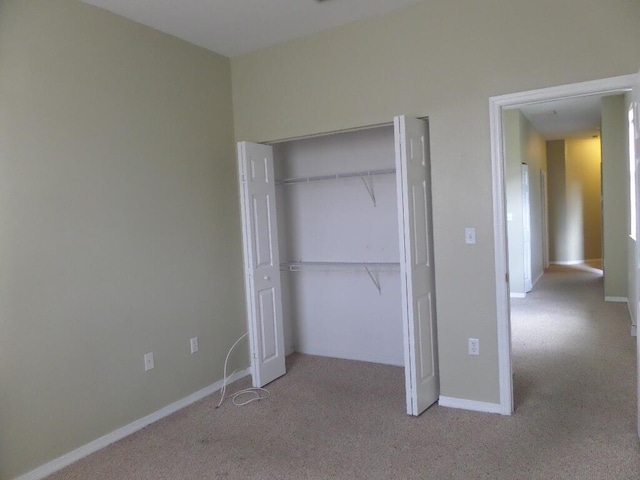 unfurnished bedroom featuring carpet, a closet, and baseboards