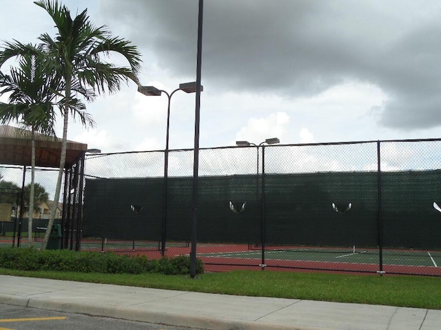 view of tennis court featuring fence