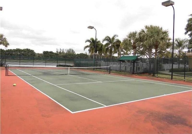 view of tennis court with fence and community basketball court