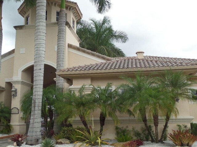view of property exterior with stucco siding and a tile roof