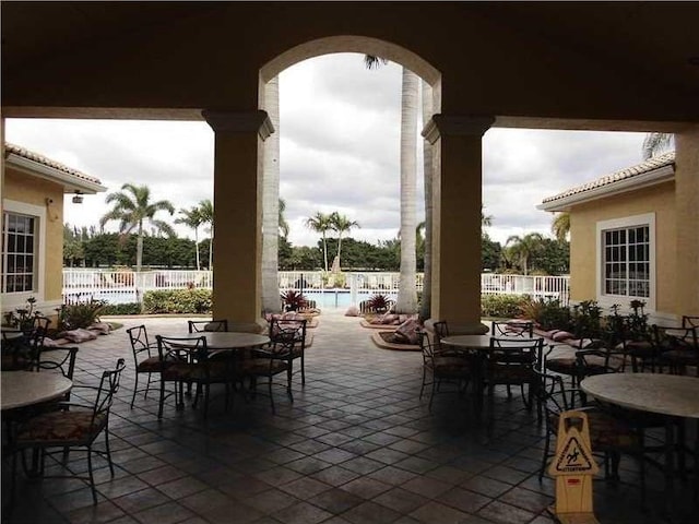 view of patio / terrace featuring fence, a community pool, and outdoor dining area