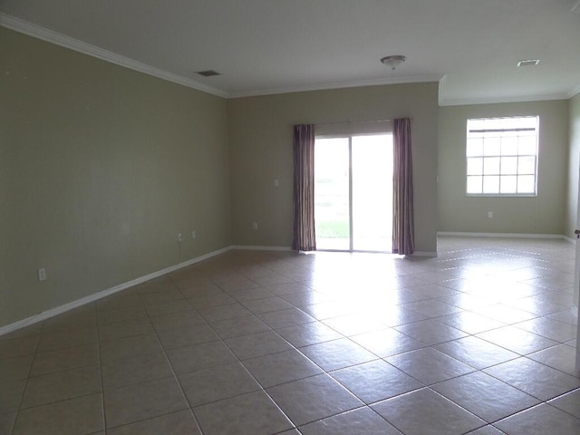tiled spare room featuring ornamental molding and baseboards