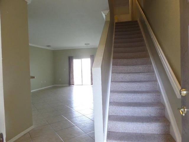 stairs with tile patterned floors, ornamental molding, and baseboards