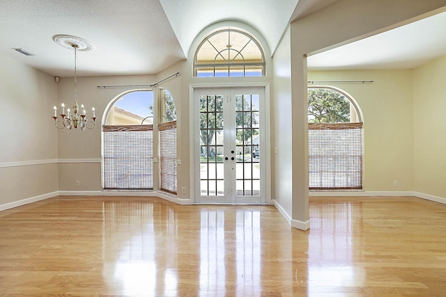 227 Shorewood Way, Jupiter, FL 33458 - entryway with light wood finished floors, a chandelier, and baseboards
