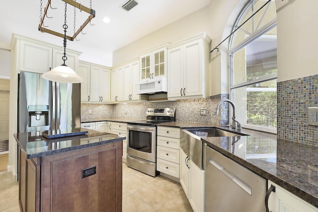 227 Shorewood Way, Jupiter, FL 33458 - kitchen featuring stainless steel appliances, dark stone countertops, a sink, glass insert cabinets, and hanging light fixtures