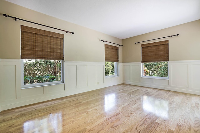 227 Shorewood Way, Jupiter, FL 33458 - empty room with a decorative wall, a wainscoted wall, a barn door, and wood finished floors