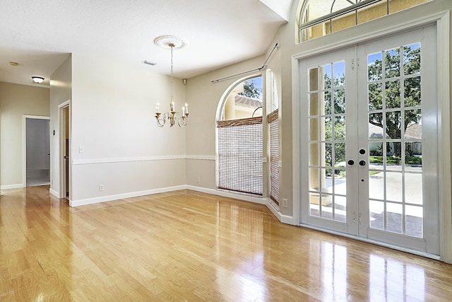 227 Shorewood Way, Jupiter, FL 33458 - unfurnished dining area featuring a chandelier, wood finished floors, baseboards, and french doors
