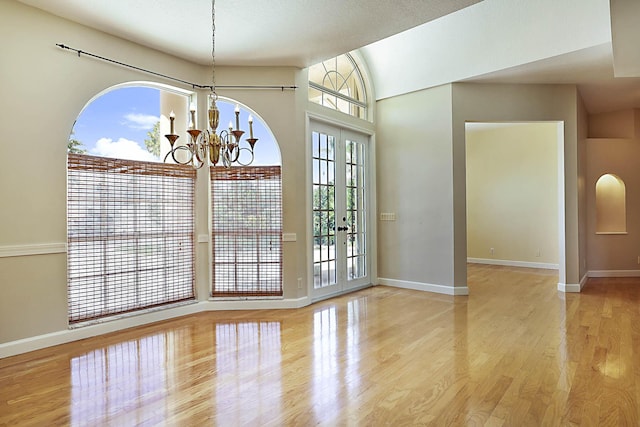 227 Shorewood Way, Jupiter, FL 33458 - unfurnished dining area with a chandelier, wood finished floors, and baseboards