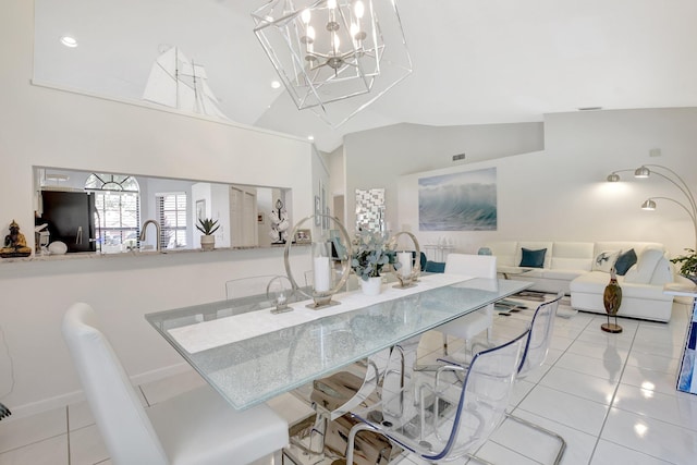 dining space featuring lofted ceiling, light tile patterned floors, and a chandelier