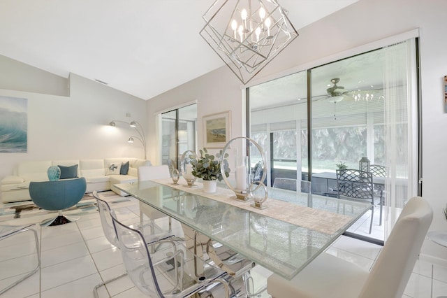 dining area featuring vaulted ceiling, tile patterned floors, a chandelier, and ceiling fan