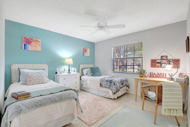 bedroom featuring a ceiling fan, tile patterned floors, and a textured ceiling