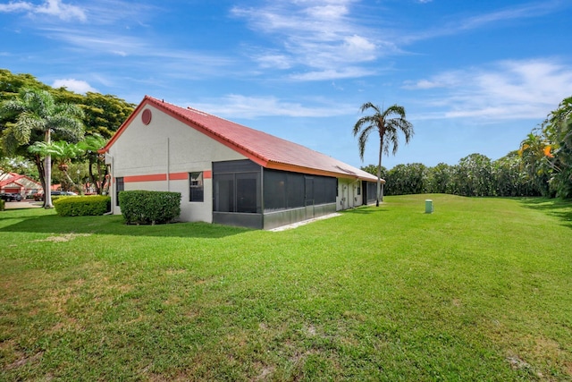 view of green lawn with a sunroom