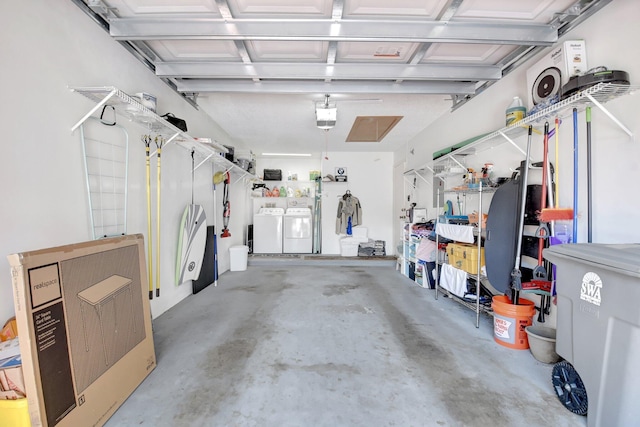 garage with separate washer and dryer and a garage door opener