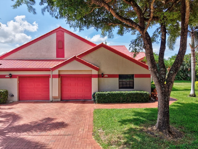view of front of house featuring stucco siding, a garage, a front lawn, and decorative driveway