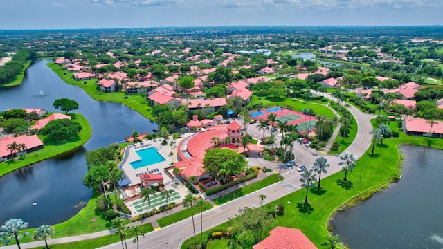 drone / aerial view of a pool and a nearby body of water