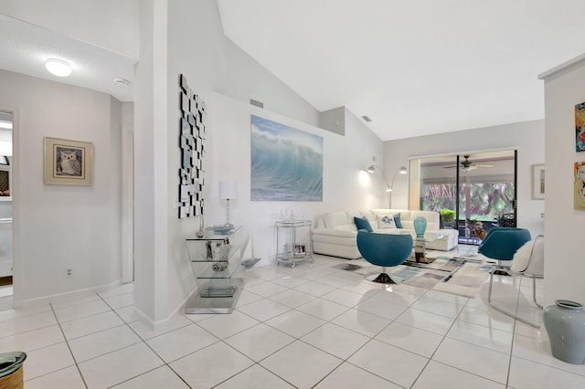 tiled living area featuring vaulted ceiling, ceiling fan, and baseboards