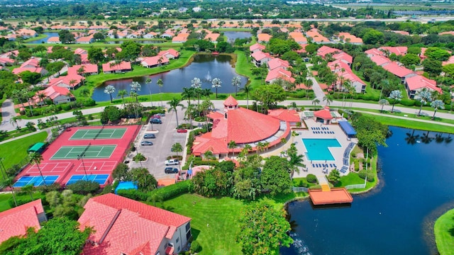 aerial perspective of suburban area featuring a large body of water and a pool area
