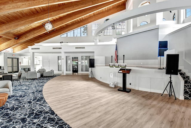 living area with plenty of natural light, wood finished floors, high vaulted ceiling, wooden ceiling, and beamed ceiling
