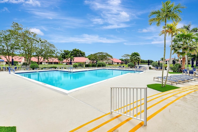 community pool featuring a patio and fence