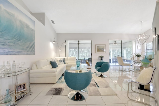 living area featuring lofted ceiling, tile patterned flooring, a chandelier, and ceiling fan