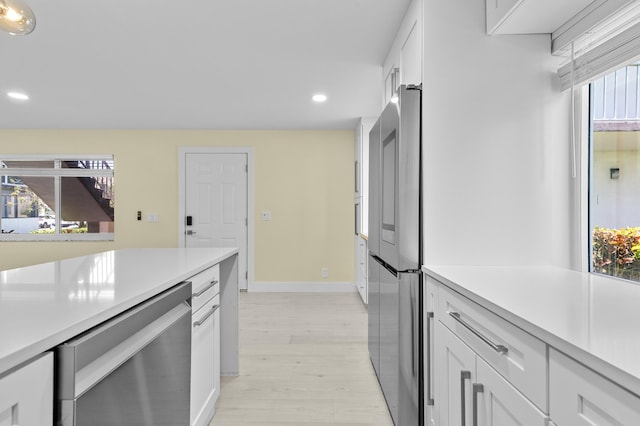 969 Normandy U, Delray Beach, FL 33484 - kitchen with stainless steel appliances, light countertops, recessed lighting, white cabinets, and light wood-style flooring