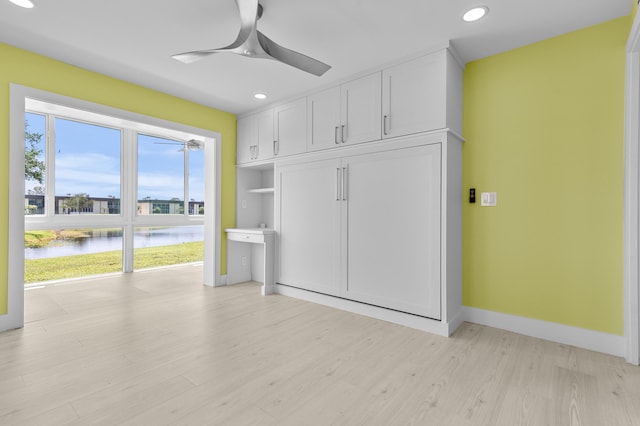 969 Normandy U, Delray Beach, FL 33484 - unfurnished living room featuring a water view, a ceiling fan, recessed lighting, light wood-type flooring, and baseboards