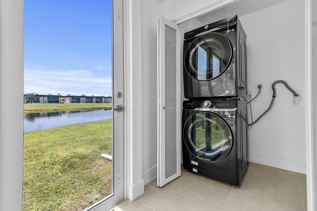 969 Normandy U, Delray Beach, FL 33484 - laundry area with stacked washing machine and dryer, a water view, and light tile patterned floors