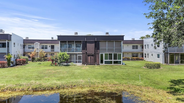 969 Normandy U, Delray Beach, FL 33484 - back of house featuring a sunroom, a lawn, and a water view