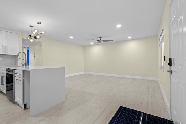 969 Normandy U, Delray Beach, FL 33484 - kitchen featuring light countertops, light wood-type flooring, white cabinets, a chandelier, and recessed lighting