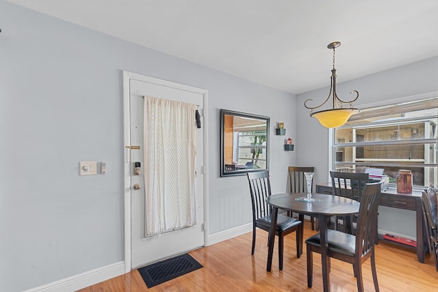 dining area with light wood finished floors and baseboards
